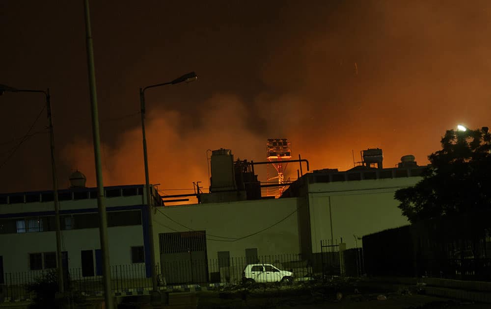 Fire illuminates the sky above Karachi airport terminal where security forces are fighting with attackers, in Pakistan. 