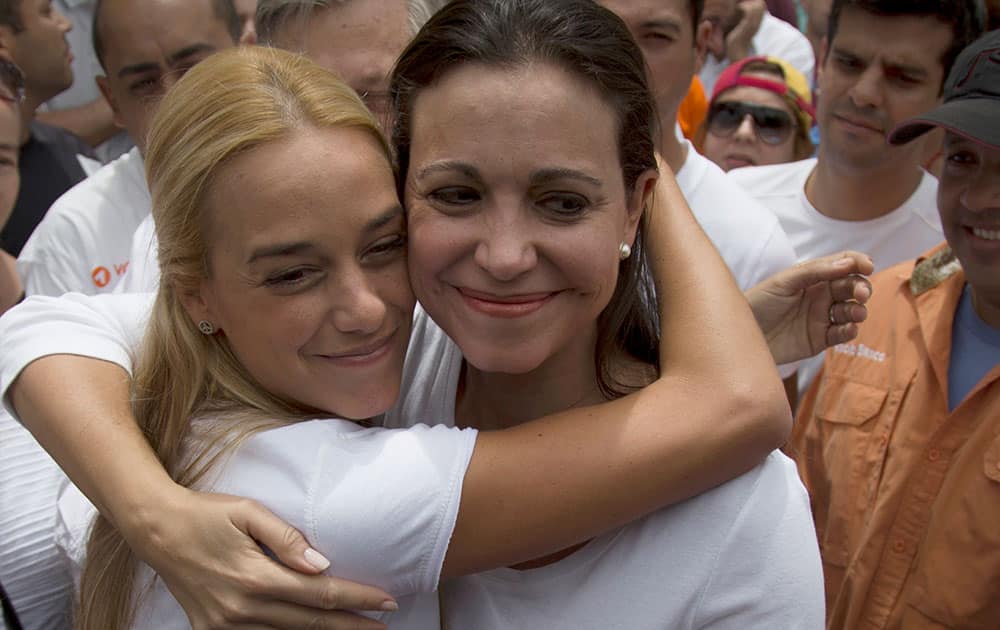 Venezuela`s opposition leader Maria Corina Machado, right, and Lilian Tintori, left, wife of jailed opposition leader Leopoldo Lopez, embrace during a rally in support of opposition leader Leopoldo Lopez in Caracas, Venezuela.