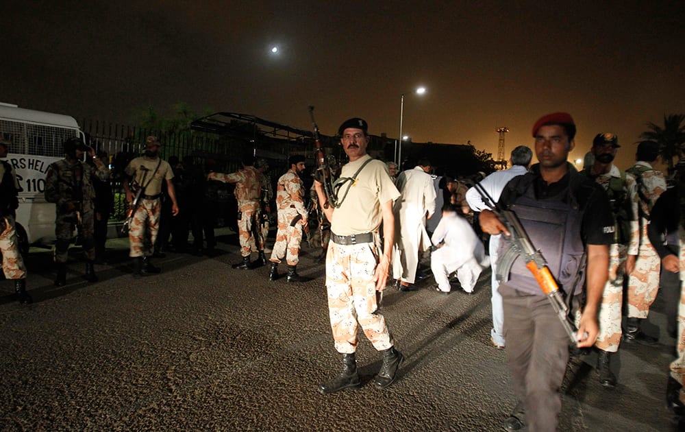 Pakistani security personnel surround the Karachi airport following an attack by unknown gunmen disguised as police guards who stormed a terminal used for VIPs and cargo in Pakistan.