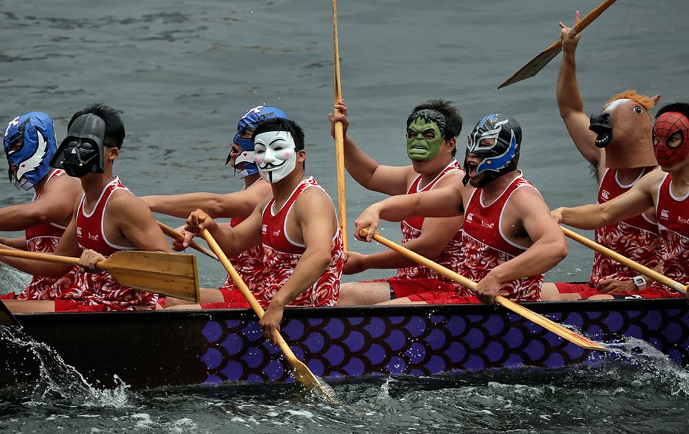 Costumed participants in their dragon boat compete during a dragon boat carnival in Hong Kong.