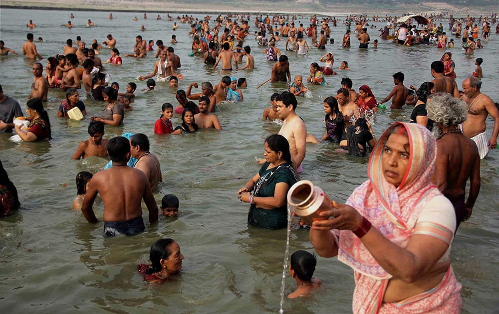 Devotees offer prayers after taking a holy dip in river Ganges on the occasion of `Ganga Dussehra` festival at river Sangam on Sunday in Allahabad.