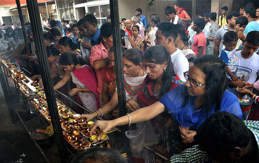 Devotees light earthen lamps while offering prayers at Kamakhya Temple in Guwahati on Sunday. Devotees from across the country have started thronging the Kamakhya Temple ahead of the annual festival `Ambubachi mela`.