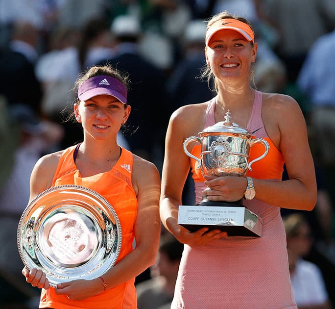 Romania`s Simona Halep, left, holds the runner-up trophy, when posing with Russia`s Maria Sharapova, right, who won the final of the French Open tennis tournament at Roland Garros stadium, in Paris.
