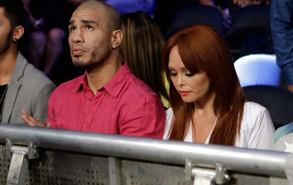 Miguel Cotto, of Puerto Rico, left, watches an undercard fight with his wife Melissa Guzman Cotto, right, before an upcoming fight with Sergio Martinez, of Argentina.