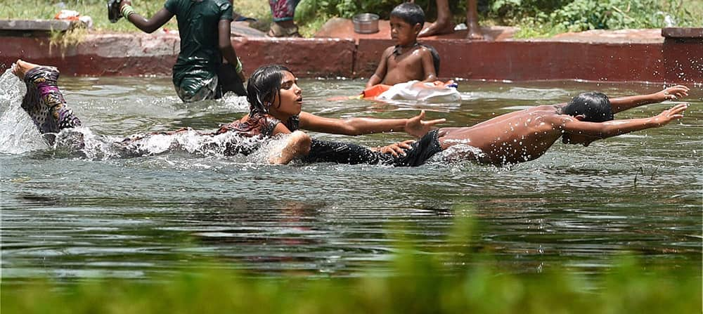 Children play in water on a hot day near Rajpath in New Delhi.