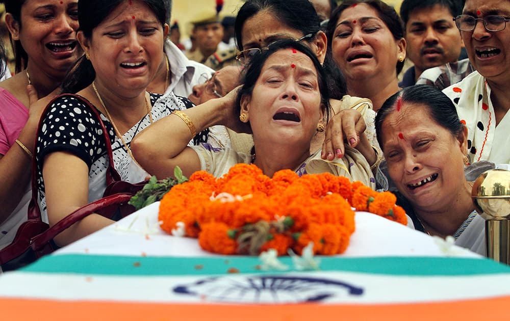 Relatives mourn by the coffin containing the body of Superintendent of Police (SP) of Hamren police district of Karbi, Anglong Nityananda Goswami, who was killed in a rebel attack, as they load his body in a vehicle during his guard of honor function at the 4th Assam Police Battalion Headquarter in Guwahati.