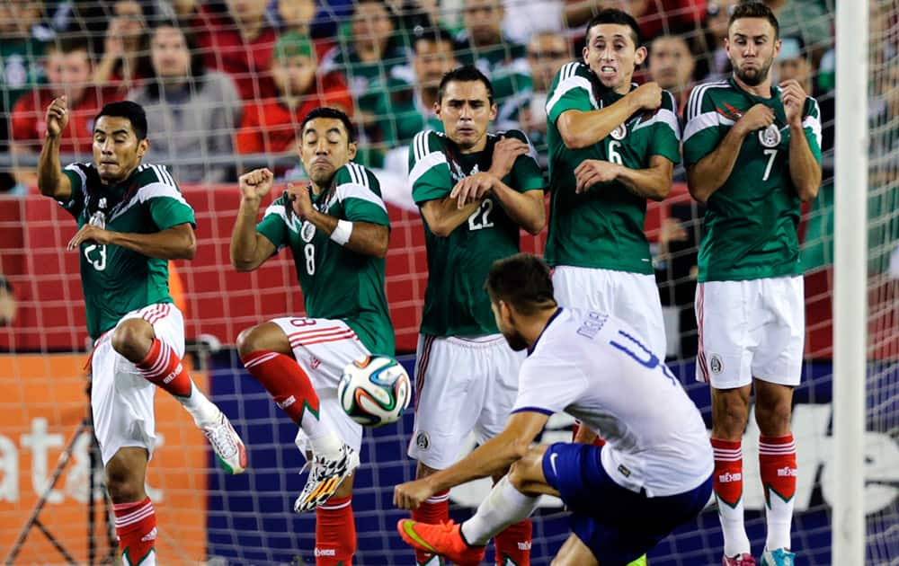 Mexico players react as Portugal midfielder Miguel Veloso takes a direct kick during the second half of their friendly soccer match in Foxborough, Mass.