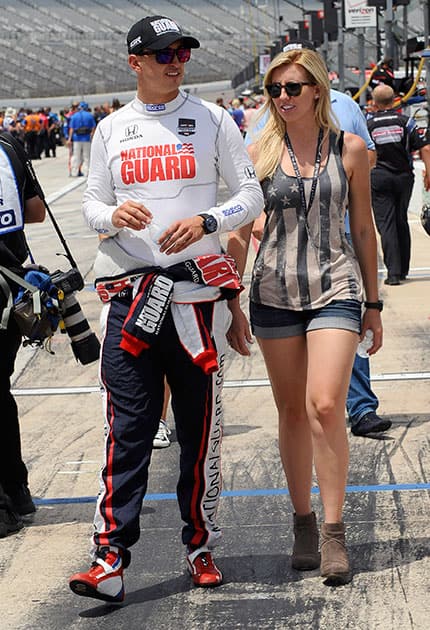 Graham Rahal, left, walks with his girlfriend NHRA driver Courtney Force walk before the qualifying for the IndyCar auto racing at Texas Motor Speedway in Fort Worth.