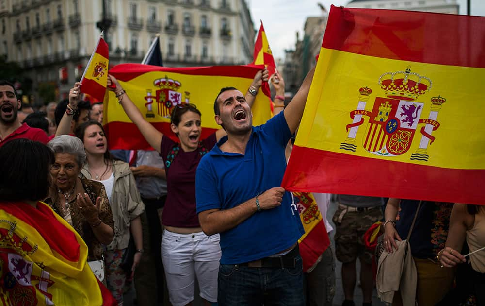 Dozens of demonstrators gather and wave Spanish flags around the monument of Charles III, a former King of Spain, during a demonstration in support of the Spanish Monarchy in the main square of Madrid.