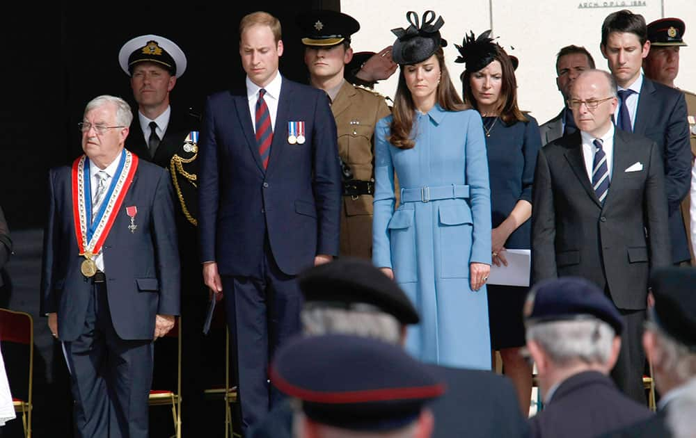 Britain`s Prince William, Duke of Cambridge, and Duchess of Cambridge, French Interior Minister Bernard Cazeneuve, right, Mayor of Arromanches Patrick Jardin, left, attend at a remembrance ceremony, in Arromanches, France.