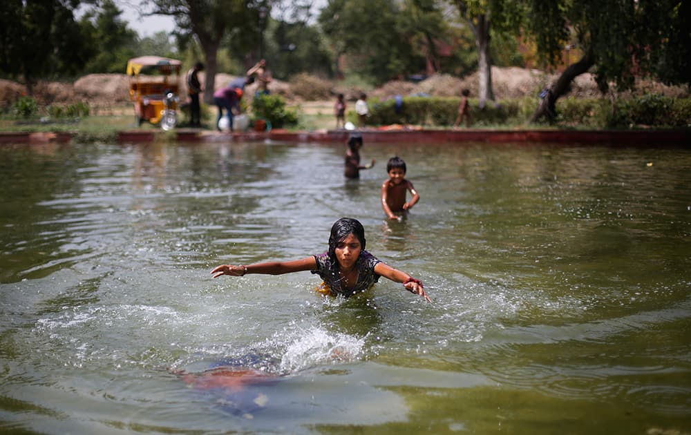 Children swim in a pond on a hot summer afternoon in New Delhi.