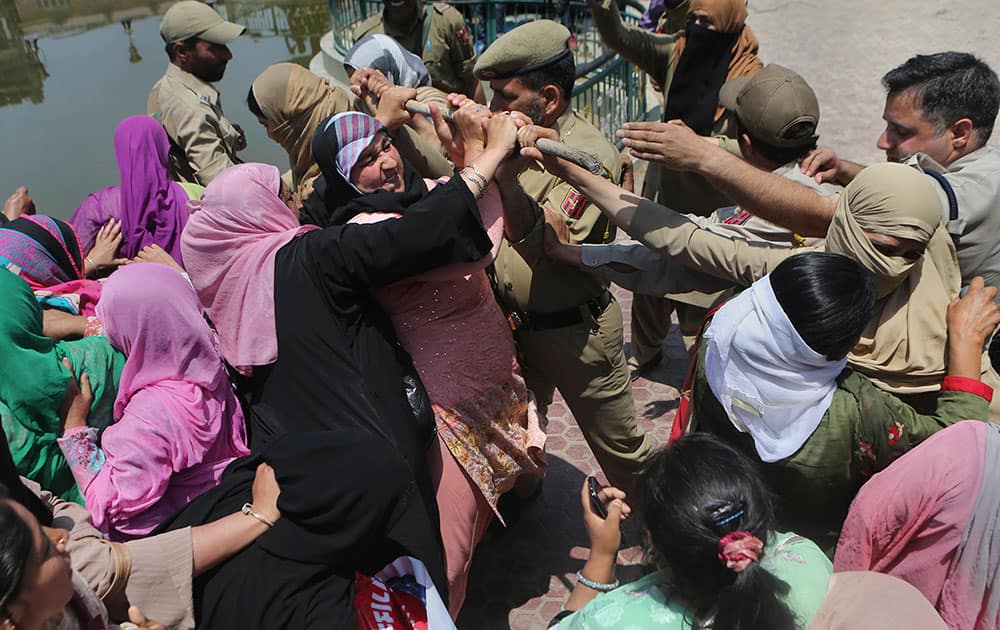 Workers of Anganwadi, a government sponsored child and mother care, scuffles with Indian police trying to stop them marching forward during a protest in Srinagar.