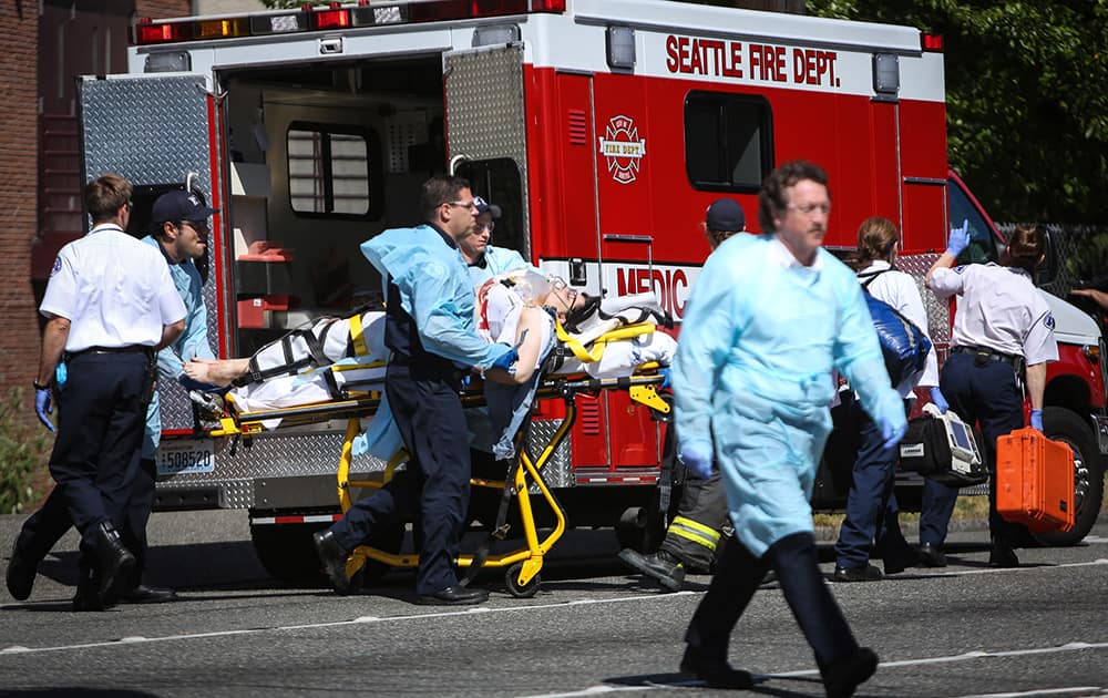 Medics wheel away a person shot at Seattle Pacific University in Seattle. A lone gunman armed with a shotgun opened fire Thursday in a building at a small Seattle university, fatally wounding one person before a student subdued him with pepper spray as he tried to reload, Seattle police said.