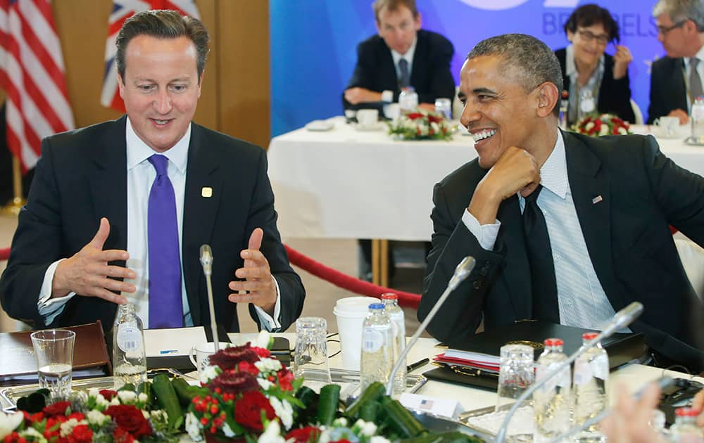 US President Barack Obama, smiles as he listens to British Prime Minister David Cameron, during a G7 working session in Brussels, Belgium.