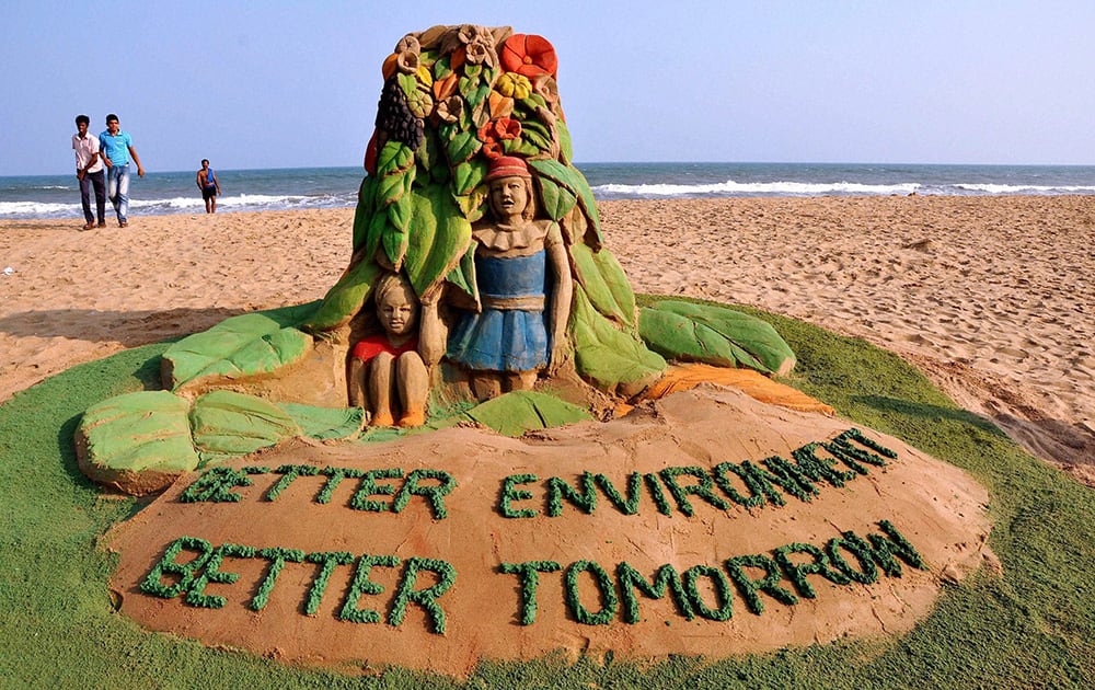 Sand artist Sudarsan Pattnaik creates a sand sculpture on World Environment Day at Puri beach in Odisha.