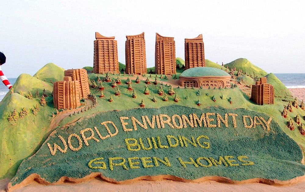 Sand artist Sudarsan Pattnaik creates a sand sculpture on World Environment Day at Puri beach in Odisha.