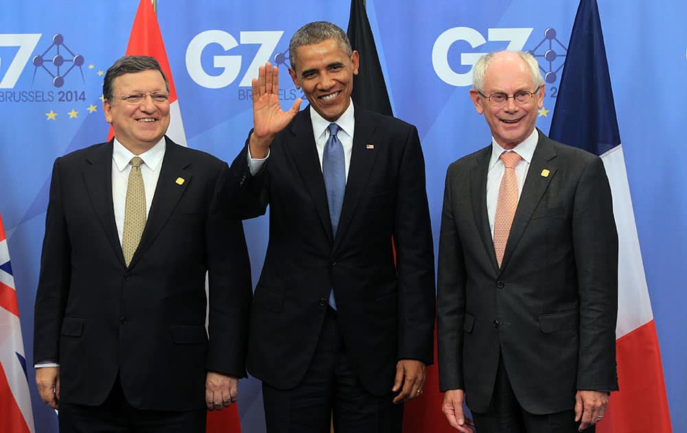 President Barack Obama, center, waves as he is welcomed by European Commission President Jose Manuel Barroso, left, and European Council President Herman Van Rompuy during arrivals for a G7 summit at the EU Council building in Brussels.