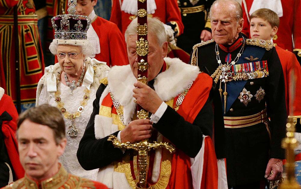 Britain`s Queen Elizabeth II, centre left, and Prince Philip, the Duke of Edinburgh, walk through the Royal Gallery, after the State Opening of Parliament, in the House of Lords, in London.