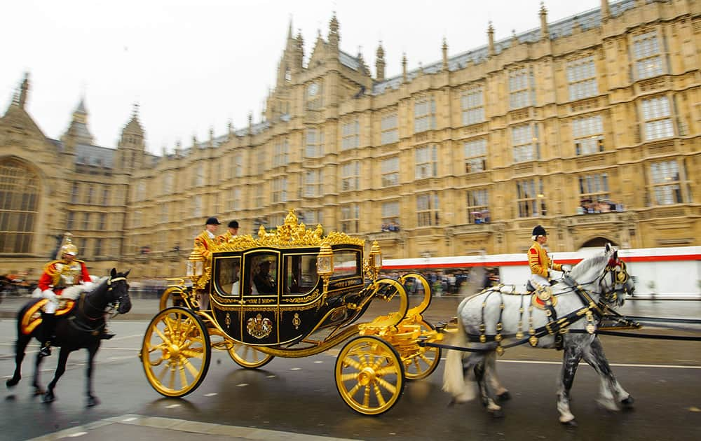 Queen Elizabeth II arrives aboard the new Diamond Jubilee Coach to attend the State Opening of Parliament at the House of Lords.