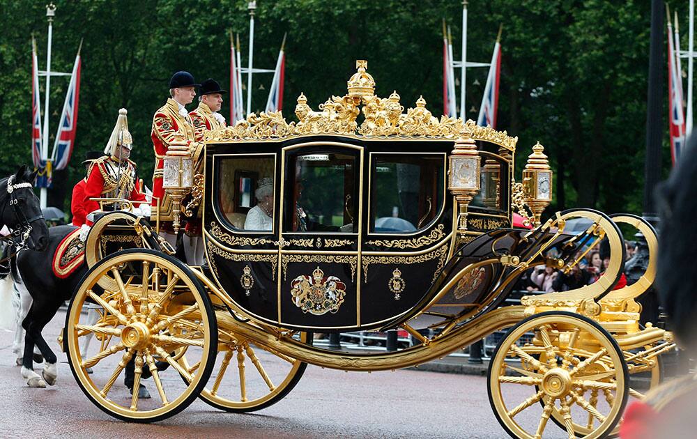 Britain`s Queen Elizabeth II rides the new Diamond Jubilee Coach as she departs Buckingham Palace on her way to the Houses of Parliament for the State Opening, in London.