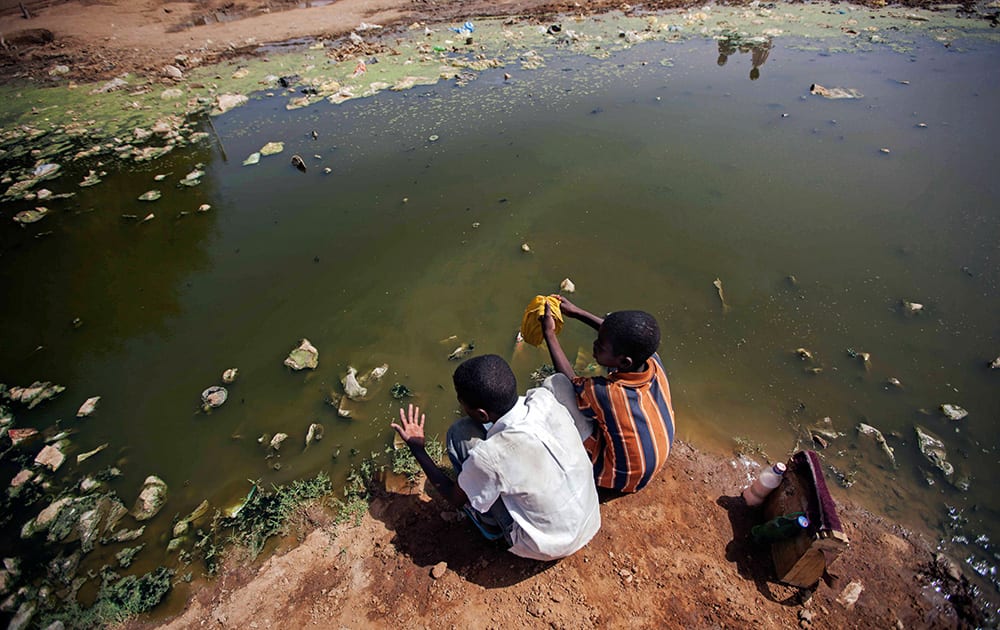 Children collect disposable water for a car wash in El Fasher, North Darfur, Sudan. Environmental experts from the Sudanese government alert that frequent contact with standing water is dangerous to children`s health. June 5 is observed by the United Nations as World Environment Day.