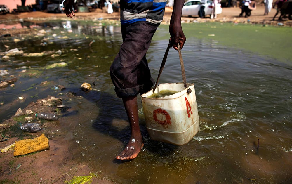 A boy collects disposable water for a car wash in El Fasher, North Darfur, Sudan. Environmental experts from the Sudanese government alert that frequent contact with standing water is dangerous to children`s health. June 5 is observed by the United Nations as World Environment Day.