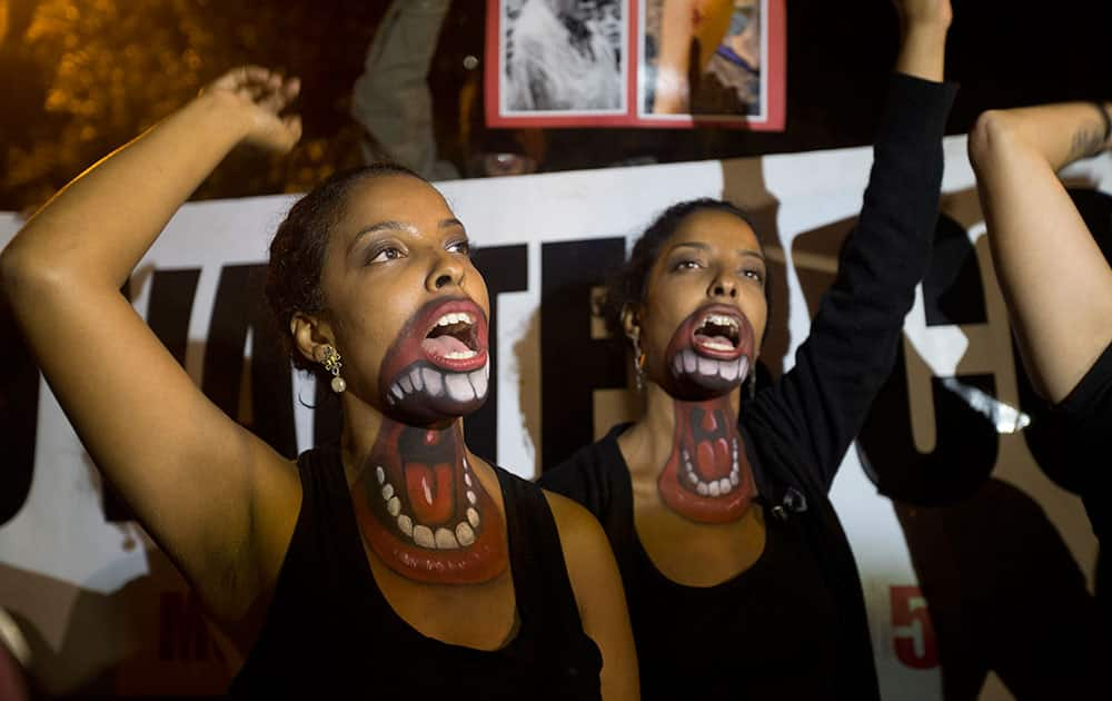 Women protest with mouths painted on them, demanding better salaries and labor conditions in Rio de Janeiro, Brazil.