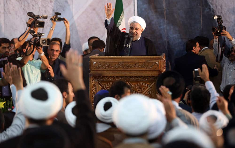 Iranian President Hassan Rouhani waves as he arrives to deliver a speech during a ceremony marking the 25th death anniversary of Ayatollah Khomeini, the founder of the Islamic Republic, at his shrine just outside Tehran, Iran.