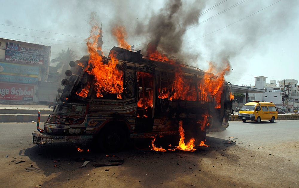 A bus burns after being set on fire by protesters condemning the arrest in London of Altaf Hussain, who heads the Muttahida Qaumi Movement, or MQM, one of Pakistan`s major political parties, in Karachi.