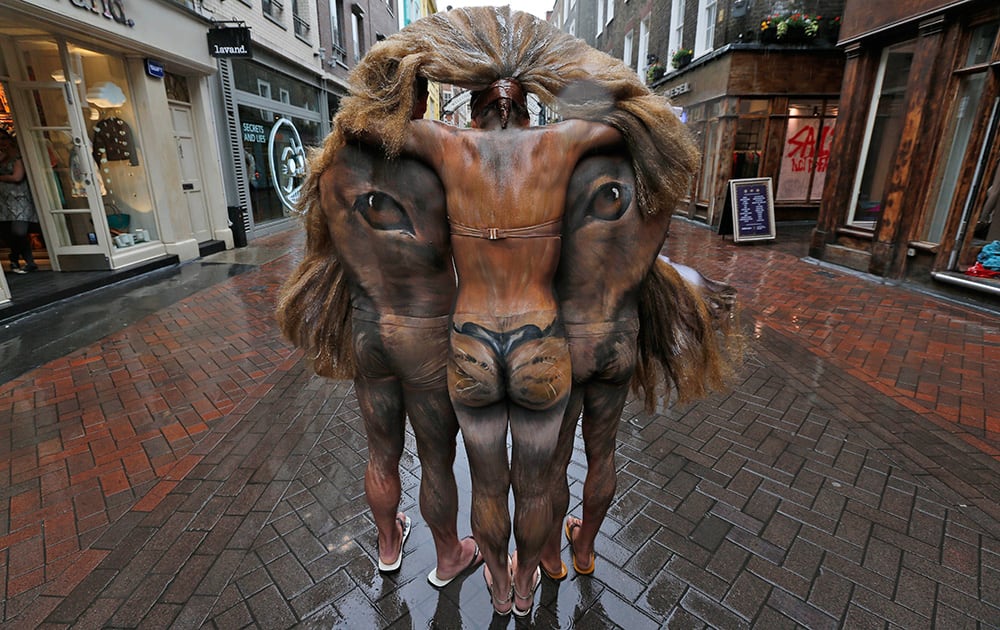 Hand-painted models depicting a lion`s head, pose for the photographers during a photo-op in central London`s Carnaby Street.