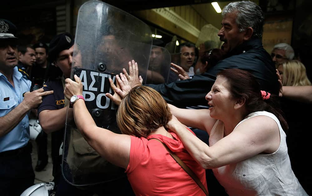 Protesting former Finance Ministry cleaning staff, who lost their jobs last year, scuffle with riot police outside a Finance Ministry building in central Athens.