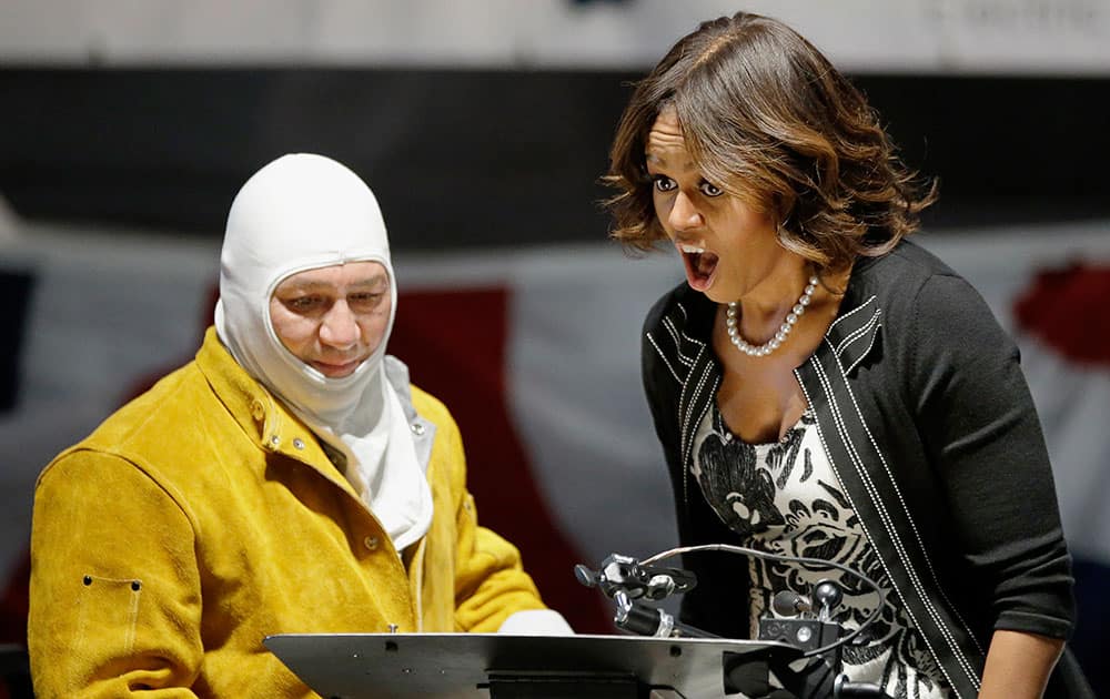 First lady Michelle Obama reacts to seeing her initials welded onto a steel plate by welder Michael Macomber during a keel-laying ceremony for a submarine that will become the USS Illinois, at the Electric Boat company in North Kingstown, RI. 