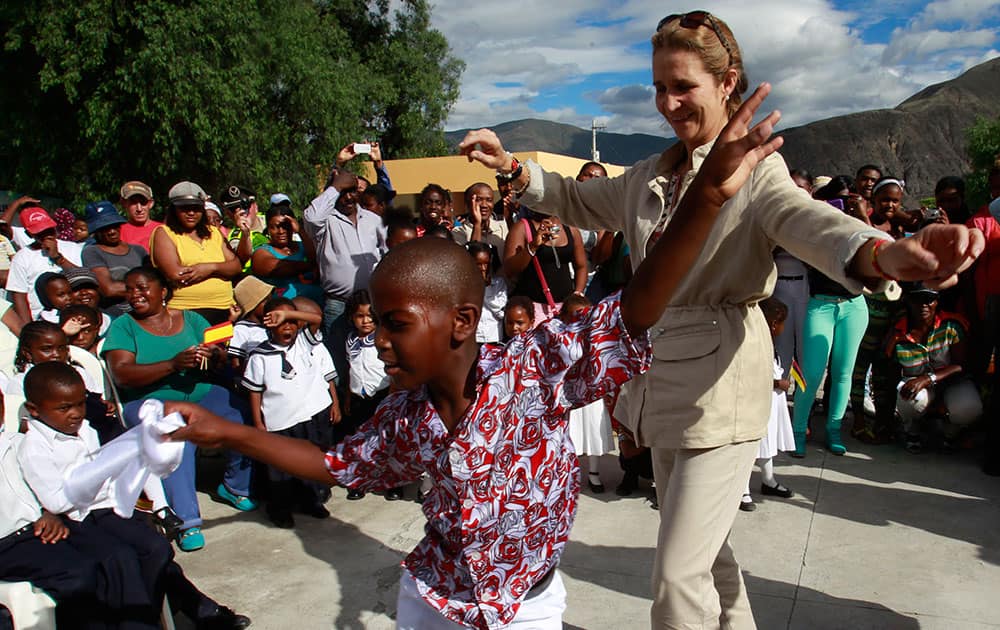 Spanish Infanta Elena de Borbon dances with a boy from the Hernando Taquez school in Mascarilla, Ecuador.