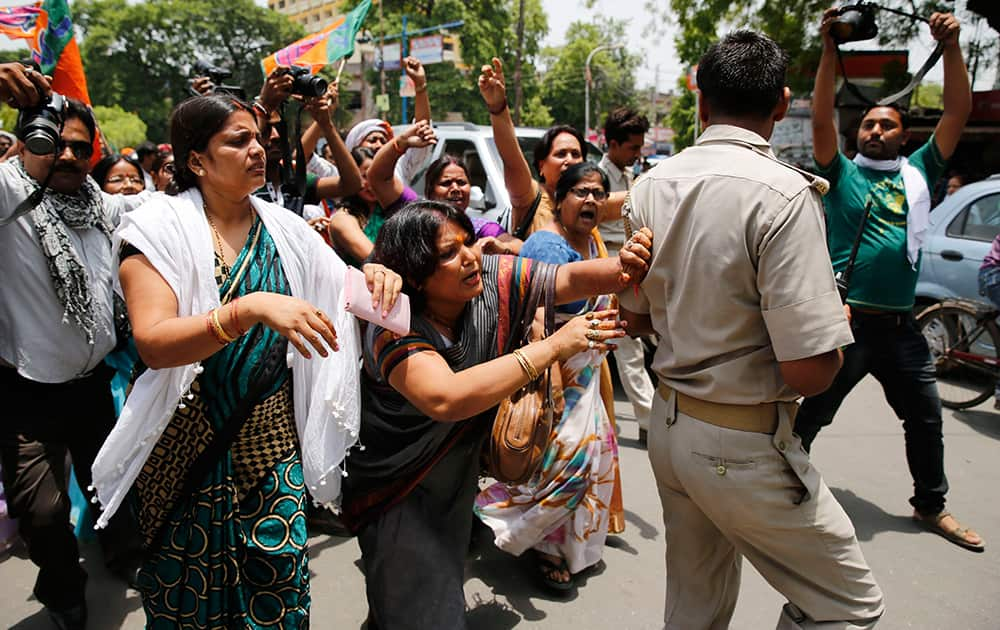 A Bharatiya Janata Party (BJP) member pushes aside a policeman blocking the path during a protest against the gang rape of two teenage girls, in Allahabad.