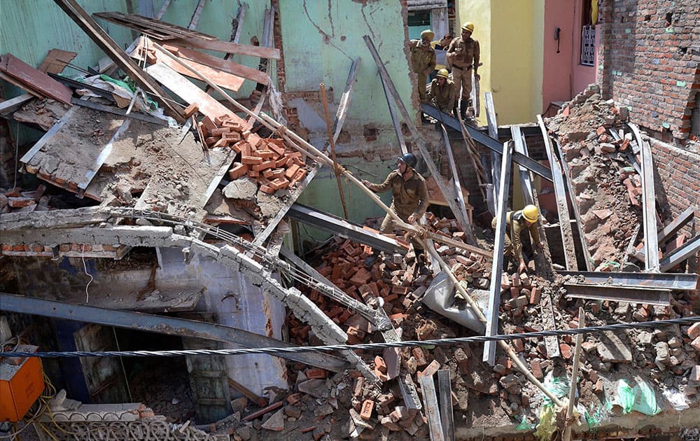 Rescuers search among the debris after a three-story building under construction collapsed in Sadar Bazar area of New Delhi.