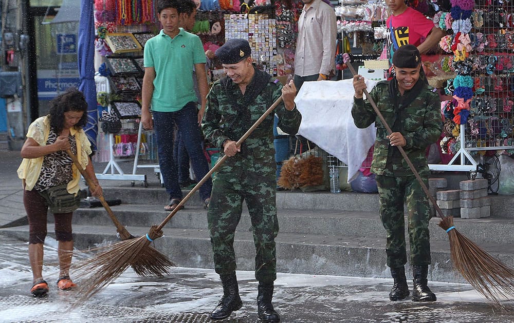 Thai soldiers and city workers sweep the ground during a big cleaning joint operation at Victory Monument in Bangkok.