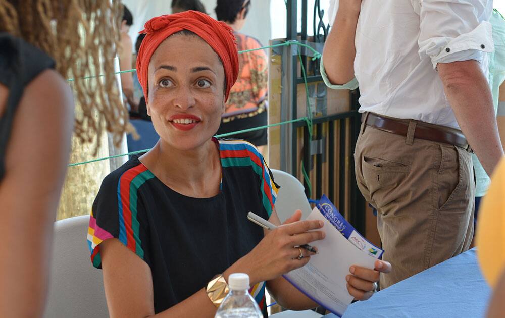 Acclaimed novelist Zadie Smith is shown signing a book for a fan in Treasure Beach, Jamaica.