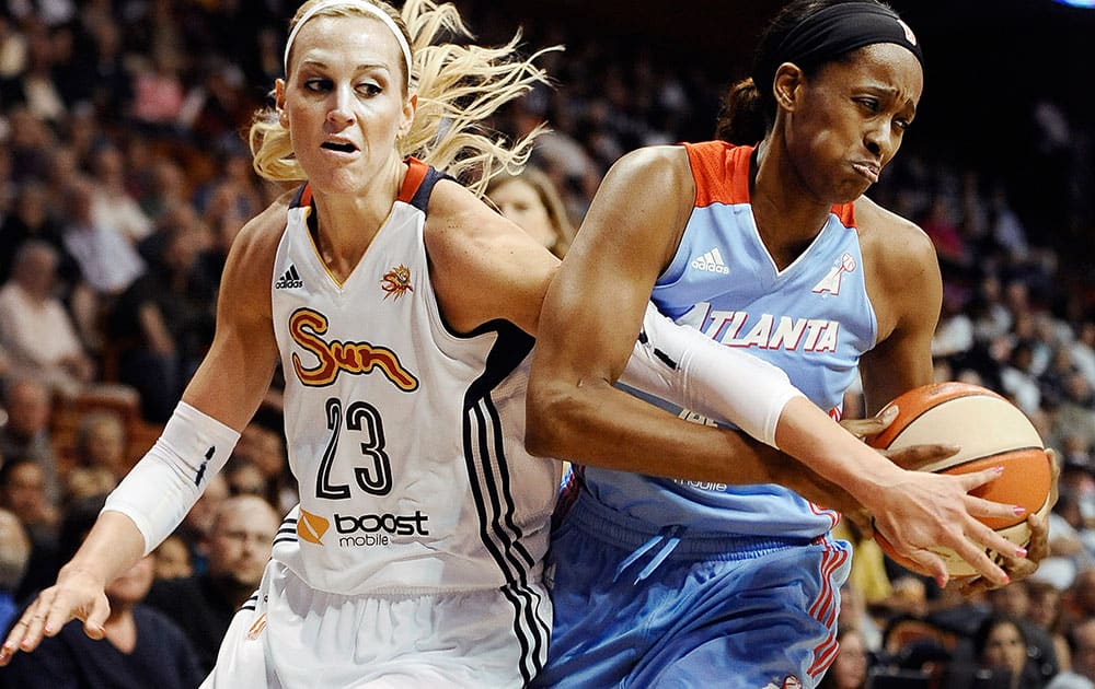 Connecticut’s Katie Douglas, left, tangles with Atlanta`s Swin Cash, right, during the first half of a WNBA basketball game, in Uncasville, Conn. 