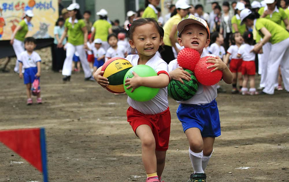 Children carrying balls run in a game during an International Children`s Day event at Pyongyang September 15 Nursery in Pyongyang, North Korea.