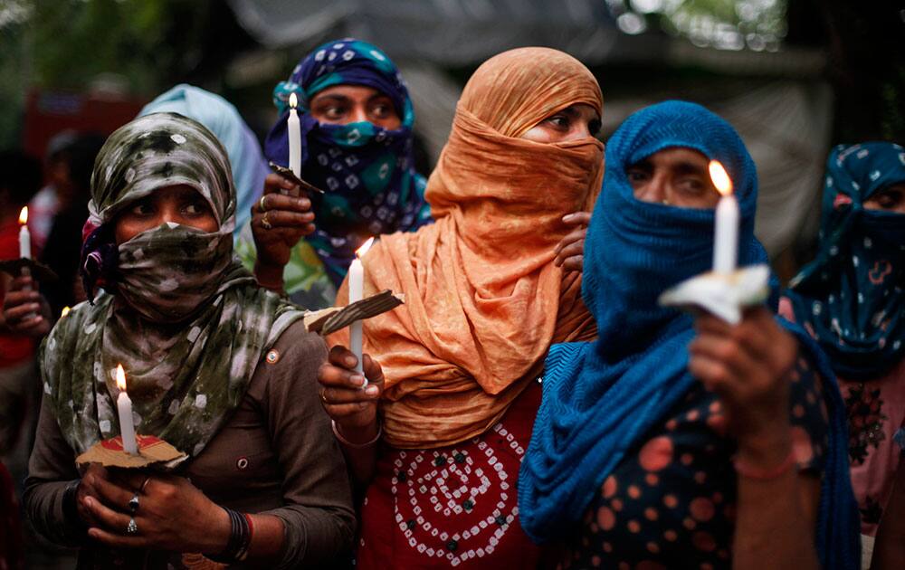 Activists hold candles during a vigil to protest against the gang rape of two teenage girls, in New Delhi.