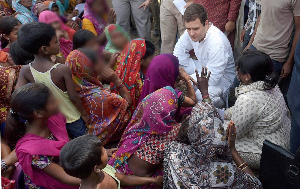 Congress Vice President Rahul Gandhi interacts with village women during his visit to the Katra Shahadatganj village where two sisters were gang raped and hanged from a tree, in Badaun district.