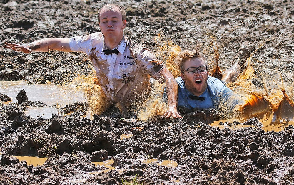 Players celebrate winning a match during the German Mud Soccer Championships in Rieste, Germany.