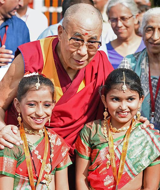 Tibetan Spiritual leader the Dalai Lama poses for a photo with children during the inauguration of a school in Mumbai.