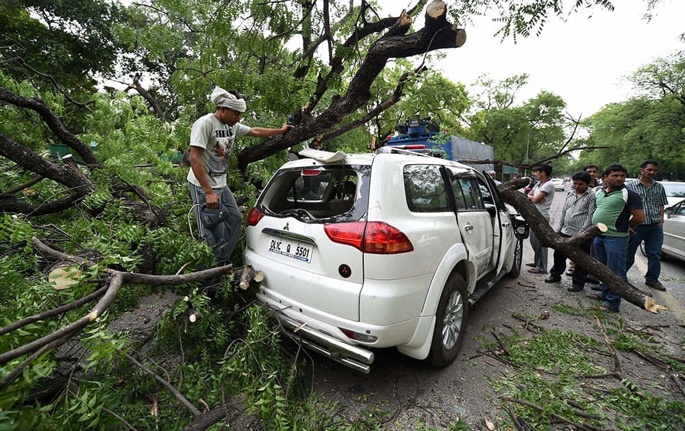 A tree branch fell on a car near Gymkhana Club after a storm accompanied by dark clouds in New Delhi.