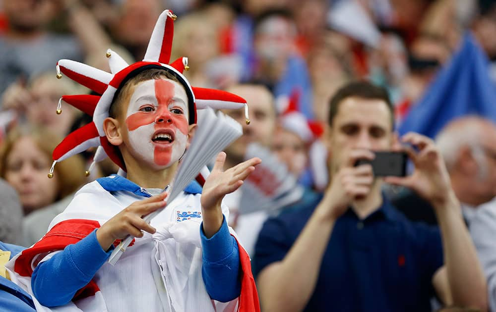 A young England supporter cheers ahead of the international friendly soccer match between England and Peru, at Wembley Stadium in London.