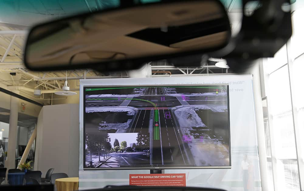 A screen showing what a Google self-driving car sees is seen through the window of one of the cars on exhibit at the Computer History Museum in Mountain View, Calif.