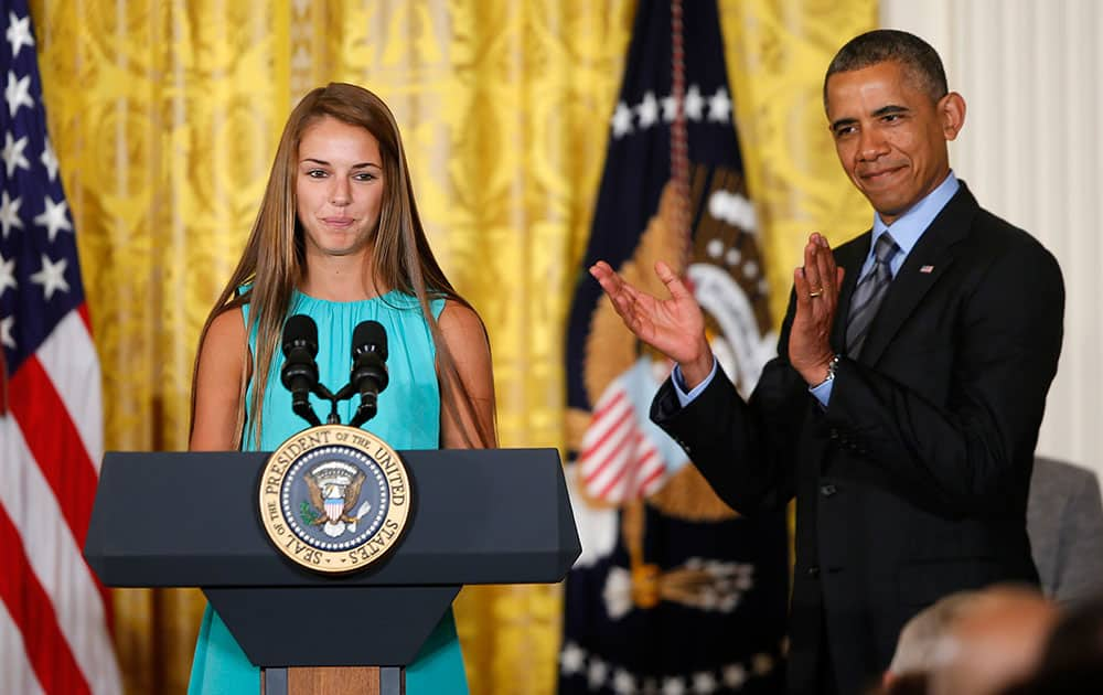 President Barack Obama applauds Victoria Bellucci, a 2014 graduate of Huntingtown High Shool in Huntingtown, Md., who suffered five concussions playing soccer, in the East Room of the White House in Washington, during the White House Healthy Kids and Safe Sports Concussion Summit. 