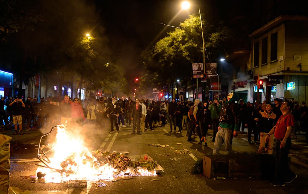 Demonstrators make a barricade with a burning containers during a protest against the eviction of social squatters from the building in Barcelona, Spain.