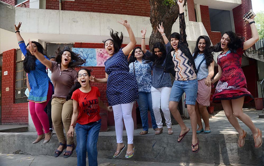Students celebrate their success after announcement of CBSE class 12th results, at their school in New Delhi.