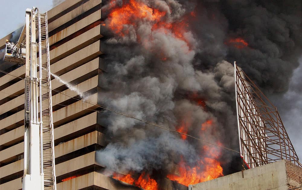 Fire fighters try to control fire that broke out in a multi-storey building in Surat.